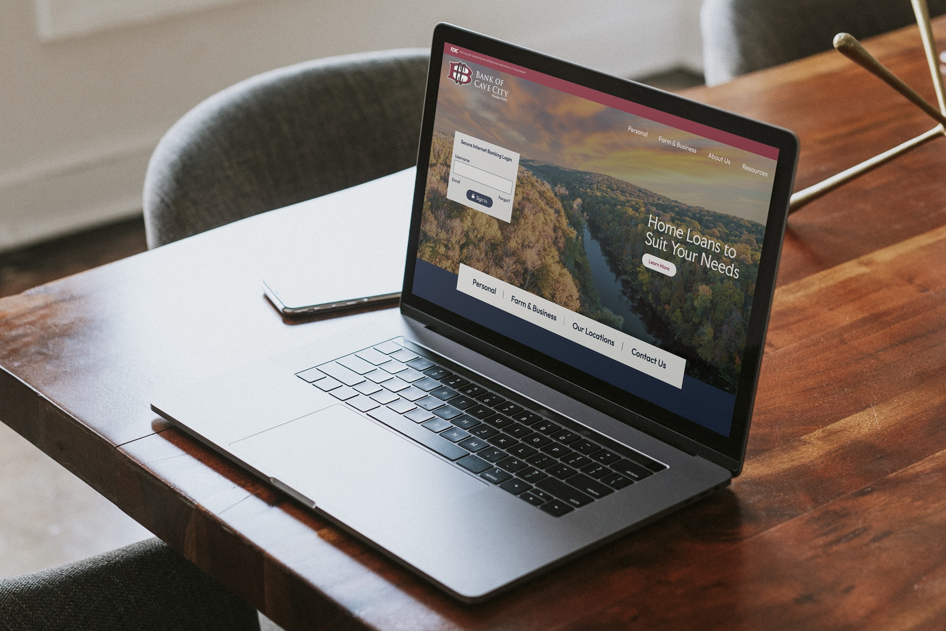 Laptop sitting on table with Bank of Cave City homepage preview 